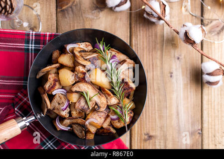 Verschiedene Snacks serviert und Bratkartoffeln mit Pilzen und Fleisch auf einem Holztisch. Köstliche traditionelle winter Essen in Russland. Feier von Weihnachten ein Stockfoto