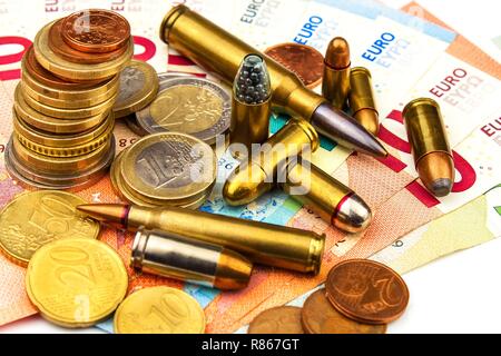 Die Euro-Münzen und -Banknoten und Patronen unterschiedlicher Kaliber. Der illegale Handel mit Munition. Verkauf von Waffen. Finanzierung des Terrorismus. Stockfoto