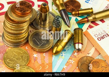 Die Euro-Münzen und -Banknoten und Patronen unterschiedlicher Kaliber. Der illegale Handel mit Munition. Verkauf von Waffen. Finanzierung des Terrorismus. Stockfoto