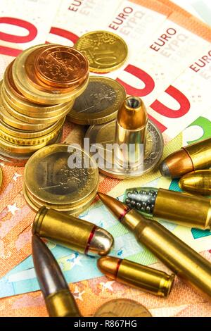 Die Euro-Münzen und -Banknoten und Patronen unterschiedlicher Kaliber. Der illegale Handel mit Munition. Verkauf von Waffen. Finanzierung des Terrorismus. Stockfoto