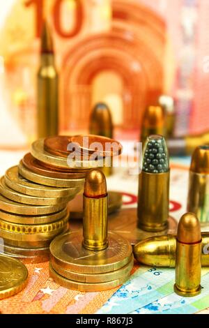 Die Euro-Münzen und -Banknoten und Patronen unterschiedlicher Kaliber. Der illegale Handel mit Munition. Verkauf von Waffen. Finanzierung des Terrorismus. Stockfoto