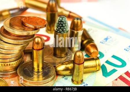 Die Euro-Münzen und -Banknoten und Patronen unterschiedlicher Kaliber. Der illegale Handel mit Munition. Verkauf von Waffen. Finanzierung des Terrorismus. Stockfoto