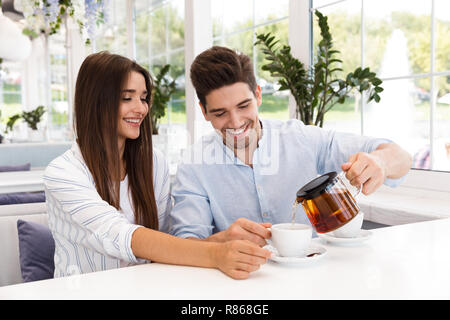 Glückliches junges Paar im Cafe sitzen, Tee trinken. Stockfoto