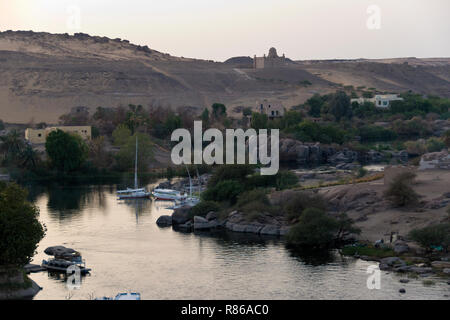 Ägyptische Boote auf dem Nil, die Westliche Wüste und das Mausoleum des Aga Khan, aus der britischen Kolonialzeit gesehen - ära Old Cataract Hotel in Assuan, Ägypten. Stockfoto