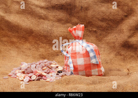 Rote Beutel und Tasten auf einem Hintergrund von sackleinen Stockfoto