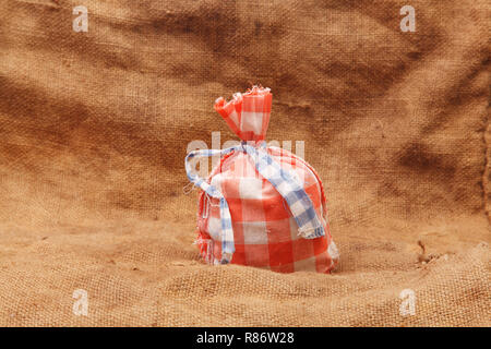 Rote Tasche auf einem Hintergrund von sackleinen Stockfoto