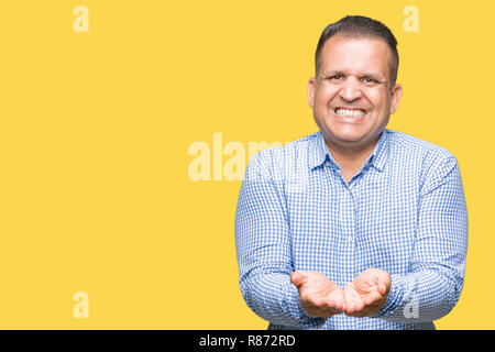 Mittleres Alter arabischer Geschäftsmann über isolierte Hintergrund lächelnd mit Hände Handflächen geben oder empfangen Geste. Halt und Schutz Stockfoto