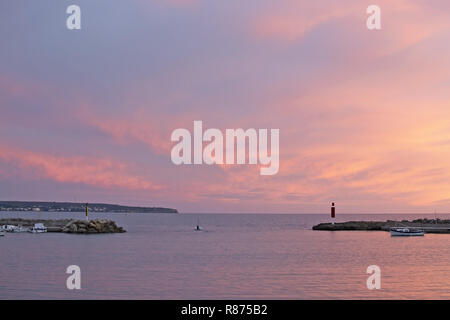 MALLORCA, SPANIEN - November 24, 2018: Pulverförmige rosa winter Sonnenuntergang Himmel und Ozean Landschaft mit Pier und Boote am 24. November 2018 auf Mallorca, Spanien. Stockfoto