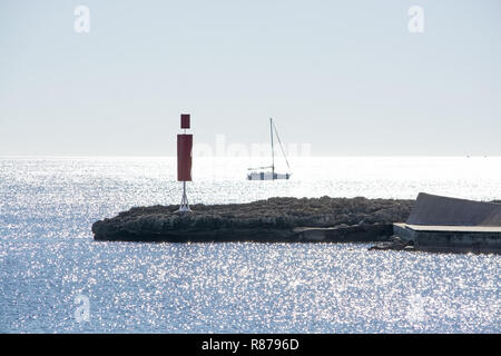 Segelboot und Pier mit Inlet an einem hellen, sonnigen Tag im Dezember auf Mallorca, Spanien. Stockfoto