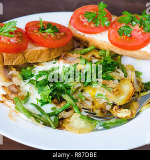 Rührei mit Tomaten, Petersilie und Brot Stockfoto