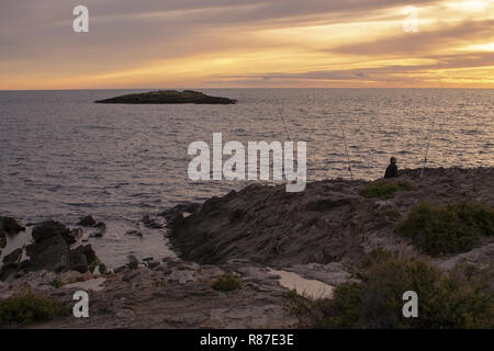 PALMA DE MALLORCA, SPANIEN - 24. NOVEMBER 2018: Silhouette Menschen mit Angeln und Meer mit Horizont bei Sonnenuntergang am 24. November 2018 auf Mallorca, S Stockfoto