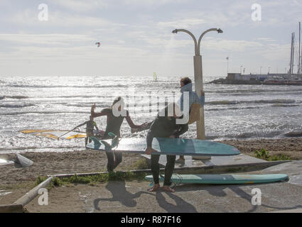 CAN PASTILLA, MALLORCA, SPANIEN - 25 NOVEMBER 2018: Surfer in der Dusche bei starkem Wind an einem sonnigen Tag am 25. November 2018 in Can Pastilla, Mallorca Stockfoto