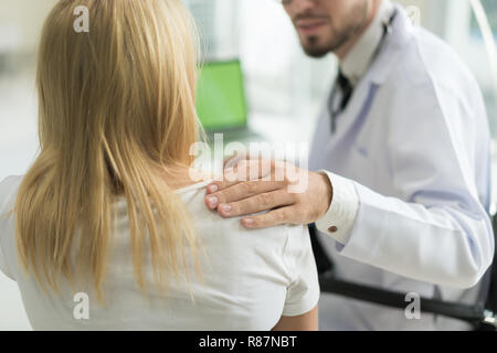 Freundliche mann Arzt Hände halten Patienten Arm am Schreibtisch für Ermutigung sitzen, Einfühlungsvermögen, Jubel und Unterstützung während der ärztlichen Untersuchung. Schlechte Nachrichten Stockfoto