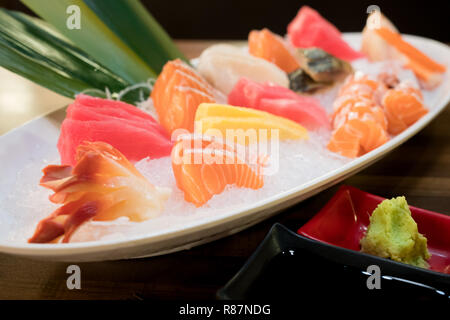 Gemischte sashimi Fisch in Scheiben geschnitten auf Eis im weiße Schüssel. Sashimi Lachs Thunfisch Hamachi Garnelen und Surf Ruhig, roher Fisch, japanisch Essen in asiatischen Restaurant. Stockfoto