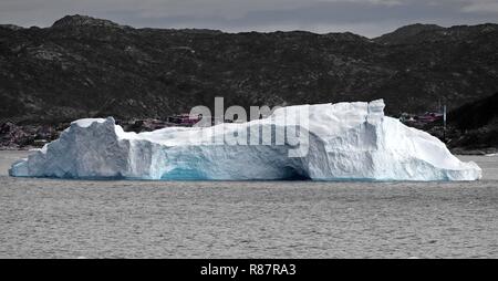 Grönland Disko Bucht: Eisberg mit Gletschertor. Im Hintergrund Ilulissat. Stockfoto