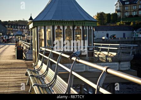 Eine taube ruht auf dem Geländer in der Nähe eines Kiosk auf Bangor Pier in der Morgendämmerung, Bangor, Gwynedd, Wales, Großbritannien Stockfoto