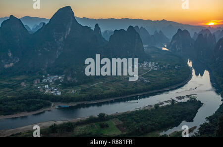 Sonnenaufgang über dem Fluss Li Ab Xianggong Berg, Guilin, Yangshuo, China gesehen. Landschaft ist in Silhouette mit orange Sonne auf der oberen, rechten. Stockfoto