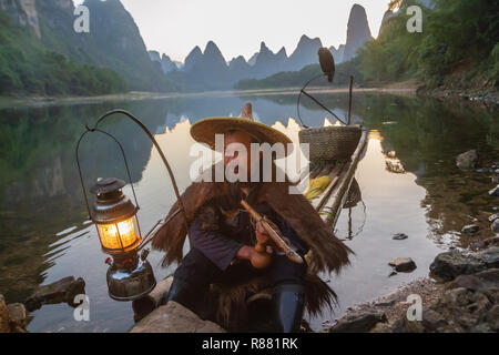 Chinesische Kormoran Fischer auf floss in See mit Rohr und Fanggeräte in Guilin, China. Stockfoto