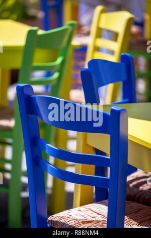 Bunte Stühle und Tische im Freien. Fokus auf der Vorderseite. Stock Bild. Stockfoto