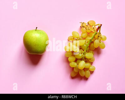 Grüner Apfel und Trauben im Studio isoliert Vor einem rosa Hintergrund von oben betrachtet Stockfoto