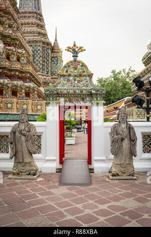 Zwei steinerne Zierpflanzen Soldaten guard eine Tür in den Gärten der Was oder was Pho Phra Tempel des reclnining Bhudda Bangkok Thailand Stockfoto