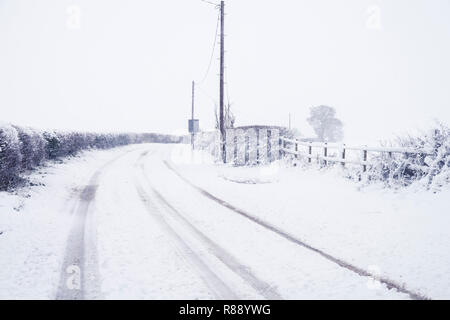 Winterliche Szene von Lane von Hatton Bank Hampton Lucy in Warwickshire, Großbritannien in einem Blizzard und mit Schnee bedeckt. Stockfoto