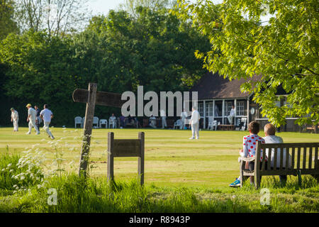 Vater und Sohn sehen Sie ein Dorf Cricket Match auf dem Dorfplatz in Rotherfield Greys, Henley-on-Thames, Oxfordshire Stockfoto