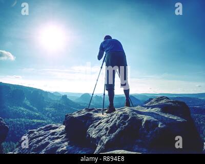 Fotograf Bilder aufnehmen mit SLR-Kamera am Mittag. Natur Landschaft Fotograf mit Teleobjektiv. Silhouette der hoch gewachsene Mann Stockfoto
