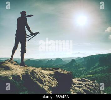 Fotograf Bilder aufnehmen mit SLR-Kamera am Mittag. Natur Landschaft Fotograf mit Teleobjektiv. Silhouette der hoch gewachsene Mann Stockfoto