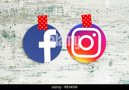 Kiew, Ukraine - September 27, 2018: Facebook und Instagram runde Symbole auf Papier gedruckt und mit rot weißen Punkten Klebeband auf altem Holz Stockfoto