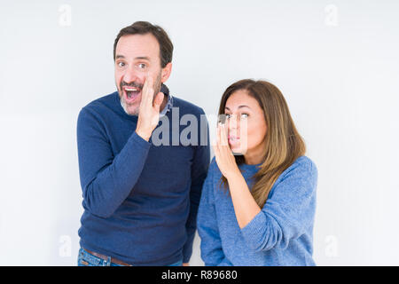 Schönen mittleren Alter Paar in Liebe über isolierte Hintergrund hand auf Mund, geheime Gerücht, Flüstern bösartige talk Gespräch Stockfoto
