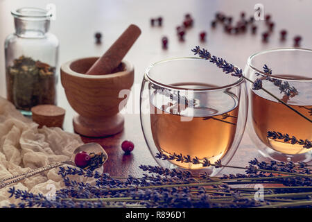 Kräutertee in einem Glas Tassen mit Lavendel und einige trockene Beeren Stockfoto