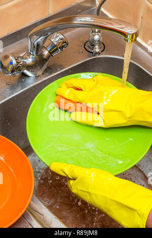Abwasch in der Küche mit Handschuhen Stockfoto