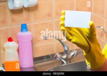 Haus und Küche Reinigung Service - Leere in der Hand und trug eine gelbe Handschuh. close-up Stockfoto