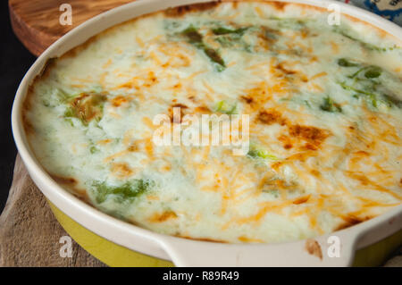 Junge Kohl Lasagne gefüllt mit Gemüse und Reis mit béchamelsoße Sauce in Keramik Teller auf einem hölzernen Hintergrund. Im rustikalen Stil. Stockfoto