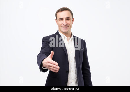 Junge Mann gibt Handshake, grüßt mit jemand,, freut sich treffen. Stockfoto