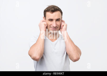 Freundliche Italiener Ohren verstopfen mit Fingern und mit einem Augenzwinkern. Stockfoto