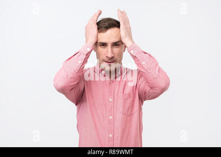 Reifer Mann mit hysterischen Ausdruck seine Hand auf den Kopf über weißen Hintergrund. Stockfoto