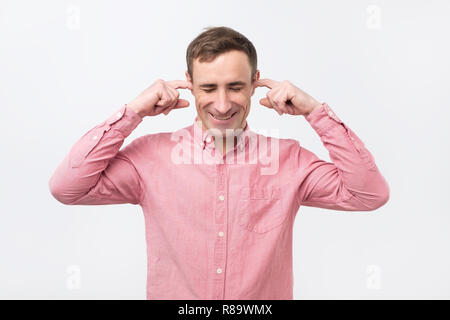 Freundliche Italiener Ohren verstopfen mit Fingern und mit einem Augenzwinkern. Stockfoto