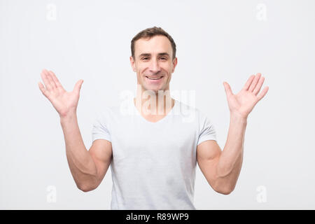 Aufgeregt, junger Kerl mit glücklichen Ausdruck und Anheben der Arme fasziniert Stockfoto