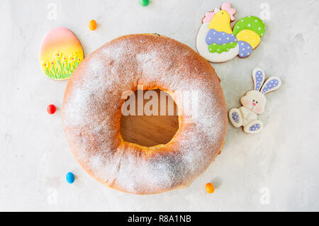 Reindling - deutsche oder österreichische Festliche yeasty Backen für Ostern. Ring Kuchen serviert auf einer Holzplatte auf einen weissen Stein Hintergrund. Stockfoto