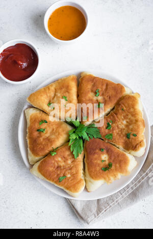 Frittierte Gemüse Kuchen mit Soßen, samsa, Samosas, echpochmak - traditionelle Fleisch oder vegetarisch gefüllte Pasteten Pasteten auf weißem Hintergrund, kopieren. Stockfoto