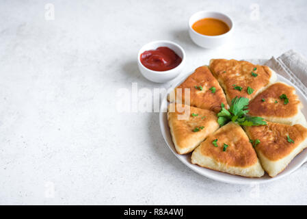 Frittierte Fleischpasteten mit Soßen, samsa, Samosas, echpochmak - traditionelle Fleisch oder vegetarisch gefüllte Pasteten Pasteten auf weißem Hintergrund, kopieren. Stockfoto