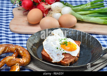 Fried meat loaf mit einem Ei sunny side up in eine eiserne Pfanne Stockfoto