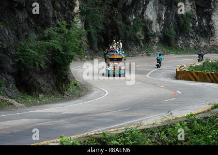 Voll gepackt mit einem Jeepney, Fahrten entlang einer gekrümmten bergigen Straße in Isabela Provinz in den Philippinen Stockfoto