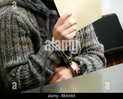 Stuttgart, Deutschland. 14 Dez, 2018. Der Beklagte hält Papier vor seinem Gesicht vor Beginn des Versuches im Gerichtssaal des Oberlandesgerichts. Er wird deutlich in die Entführung eines UN-Mitarbeiter in Syrien im Jahr 2013 beteiligt haben. (Dpa' Entführung von UN-Mitarbeiter - Flüchtling droht härtere Strafe" vom 14.12.2018): Simon Sachseder/dpa/Alamy leben Nachrichten Stockfoto