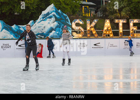 Bournemouth, Dorset, Großbritannien. 14. Dezember 2018. Besucher viel Spaß beim Eislaufen auf dem freien temporäre Eislaufbahn in Bournemouth Garten an einem Bitterkalten bewölkten Tag. Paar skate in ihrer Weihnachten Jumper. Eislaufen in festlichen Jumper - sehr geeignet, mit Schneemann und Schnee, da die Wettervorhersage für die nächsten Tage! Credit: Carolyn Jenkins/Alamy leben Nachrichten Stockfoto