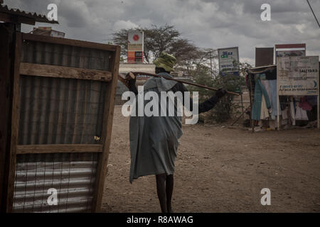 Ein Mitglied der lokalen Turkana Gemeinschaft gesehen zu Fuß durch Kakuma Stadt. Kakuma Flüchtlingslager im Nordwesten Kenias ist die Heimat von mehr als 180.000 Flüchtlinge und Asylbewerber, aus Ländern wie Uganda, Südsudan, Sudan, Äthiopien, Tansania und Somalia. Stockfoto