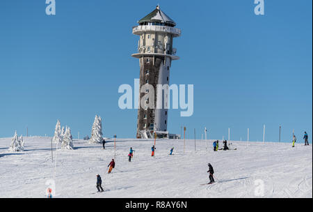 Feldberg im Schwarzwald, Deutschland. 15 Dez, 2018. Skifahrer Ski über eine Piste vor der alten Sendemast des Südwestrundfunks. Die ersten Aufzüge auf dem Feldberg im Schwarzwald eröffnet. Quelle: Patrick Seeger/dpa/Alamy leben Nachrichten Stockfoto