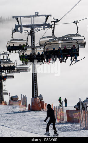 Feldberg im Schwarzwald, Deutschland. 15 Dez, 2018. Skifahrer Fahrt unter einem Sessellift über dem Meer der Wolken. Die ersten Aufzüge auf dem Feldberg im Schwarzwald eröffnet. Quelle: Patrick Seeger/dpa/Alamy leben Nachrichten Stockfoto
